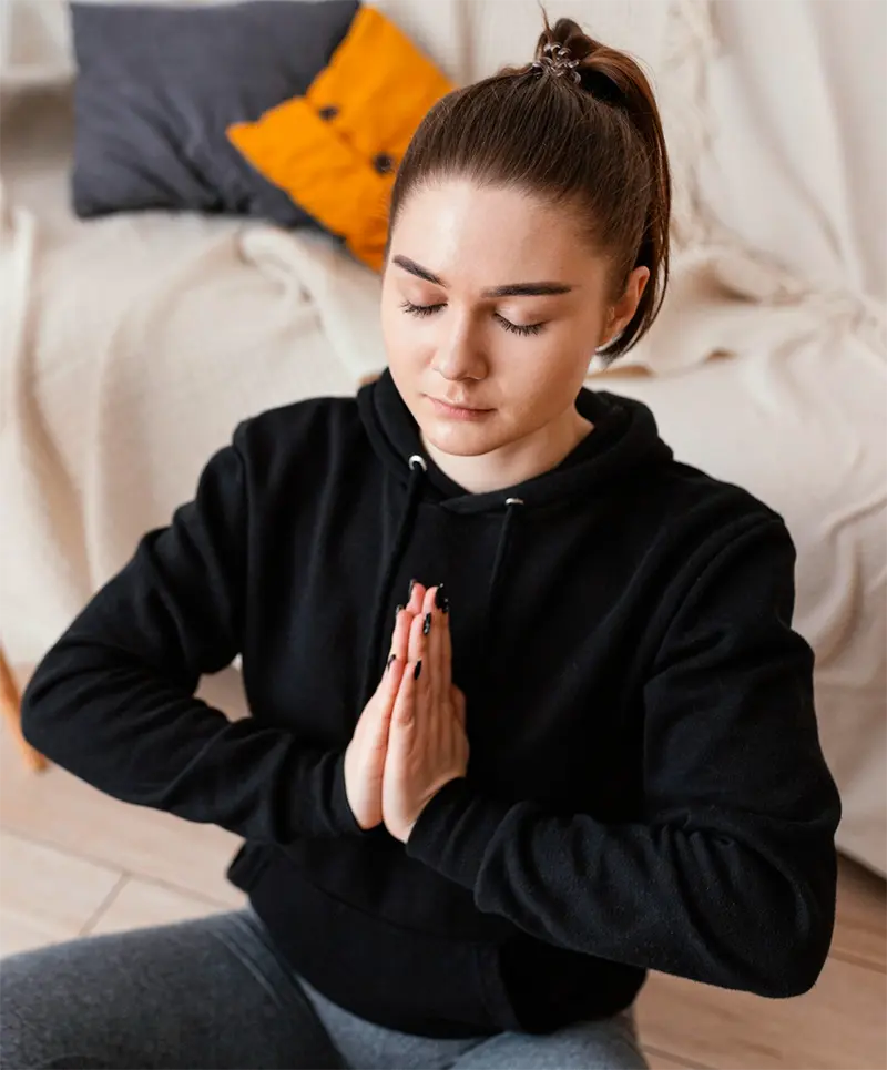 Woman practicing meditation with her hands together