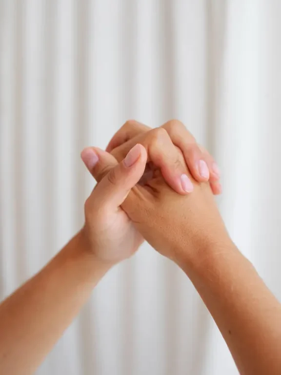 Hands held together during a supportive mentorship session